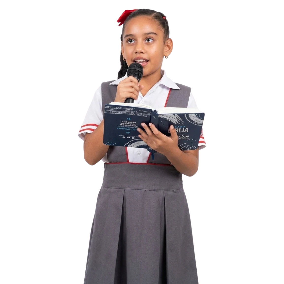 Estudiante de primaria del Gimnasio Cristiano Belén leyendo la Biblia frente al micrófono